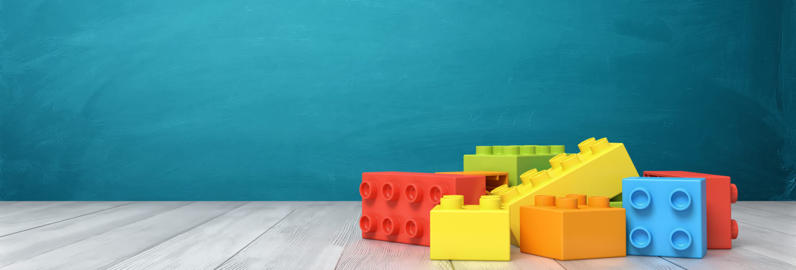 3d rendering of a toy building blocks lying in a colorful pile over a wooden desk on a blue background