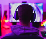 Young man wearing headset and play computer video games online - Home isolated for coronavirus outbreak