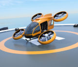 Orange self-driving passenger drone takeoff from helipad.