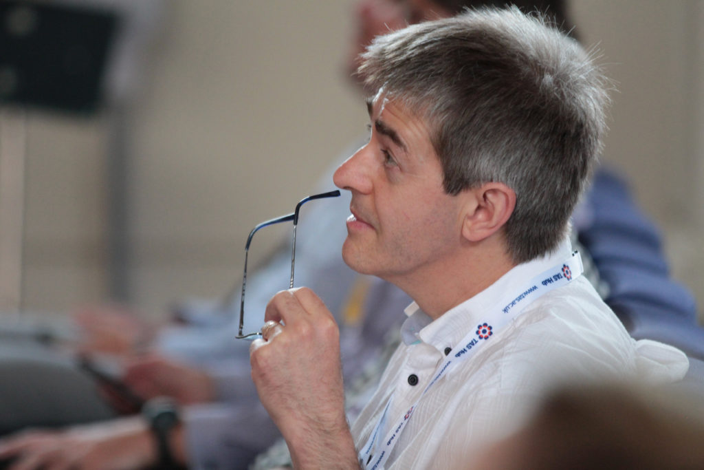 Professor Radu Calinescu holding a pair of glasses