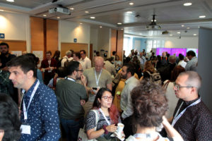 A full room of delegates gather for tea and coffee