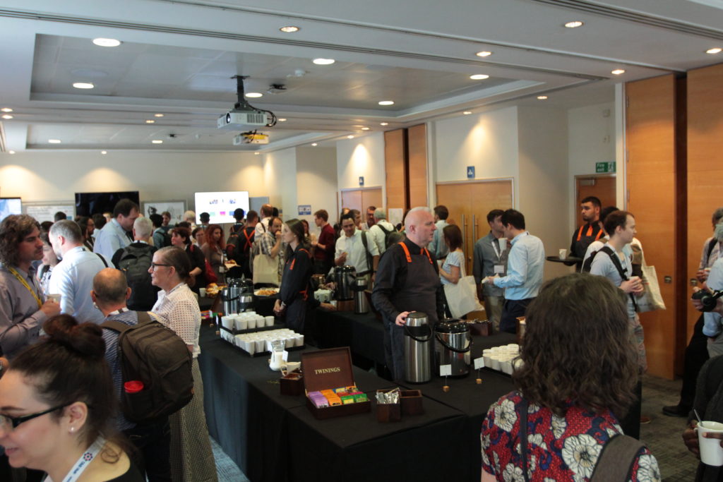 A full room of delegates gather for tea and coffee